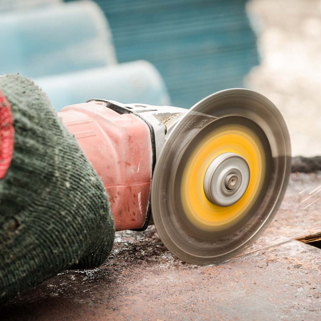 Worker cutting steel with a power tool