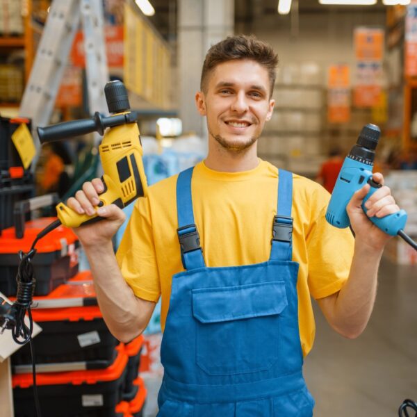 Man holds up tools in a tool shop