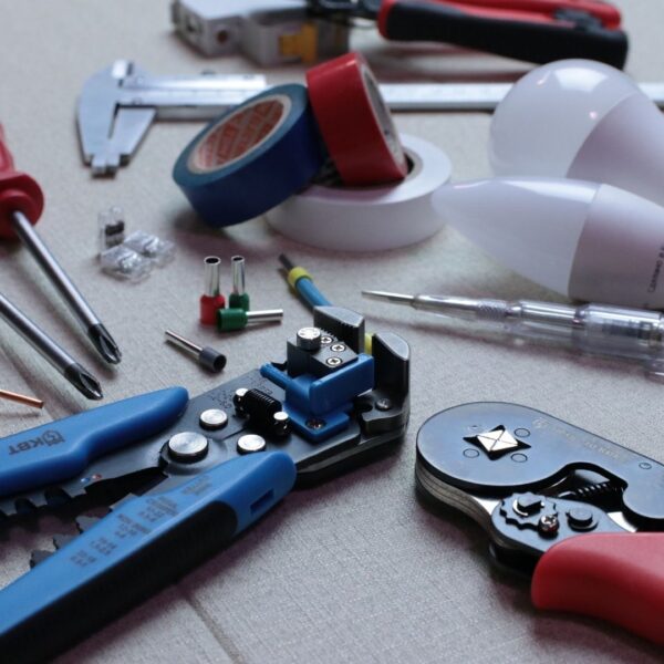 tools, lightbulbs and electrical tape on table